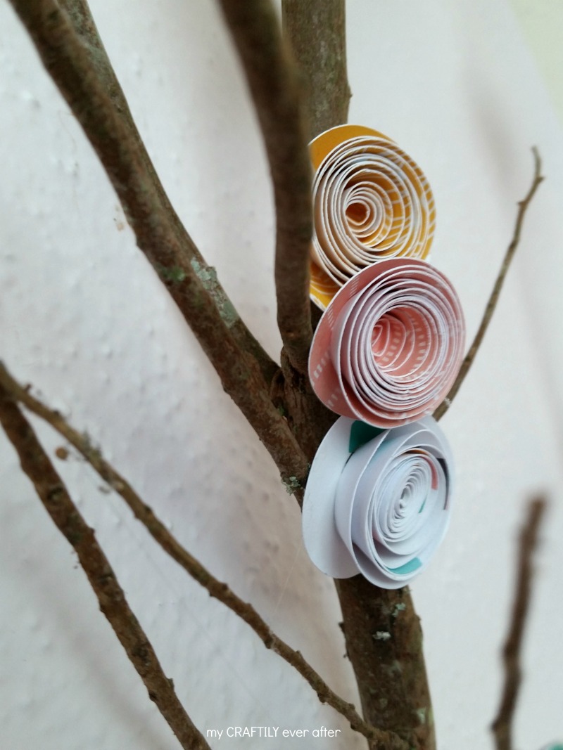 rolled paper flowers on a branch